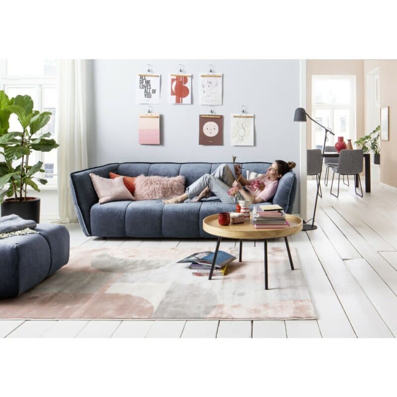 Raum.Freunde Hedda Sofa mit Chenille Bezug in Dunkelblau - Wohnbeispiel mit Frau