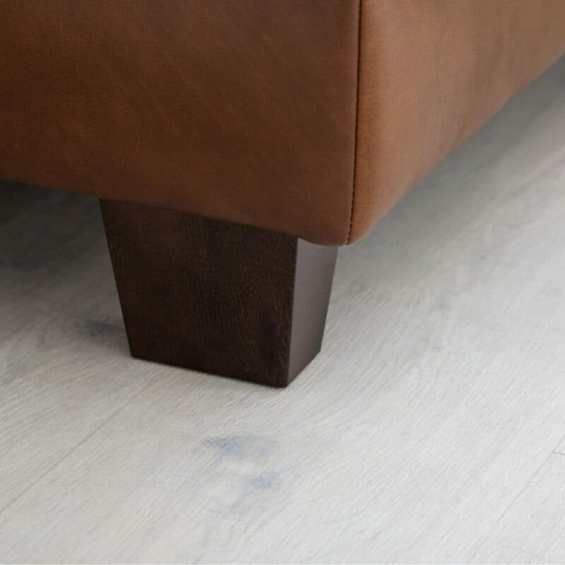 Couchliebe „Hamburg” Polsterecke mit Echtlederbezug in Credo Brandy in Detailansicht des Standfußes.