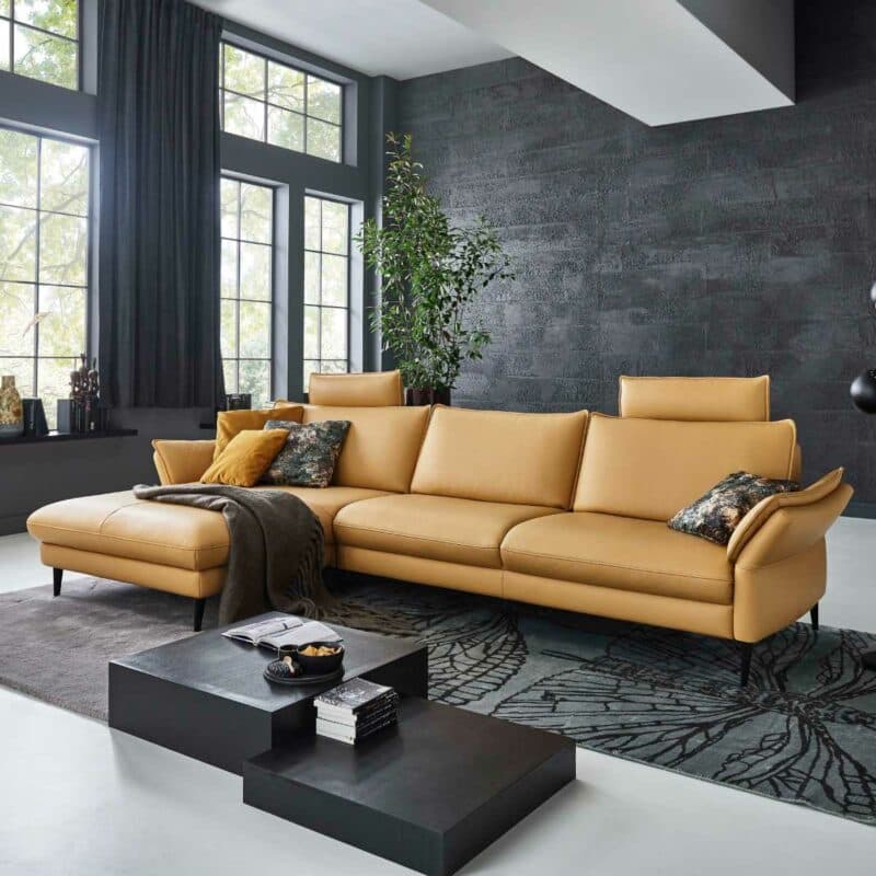 Couchliebe Houston Elementgruppe mit Lederbezug in Curry und Ottomane links als Wohnbeispiel.