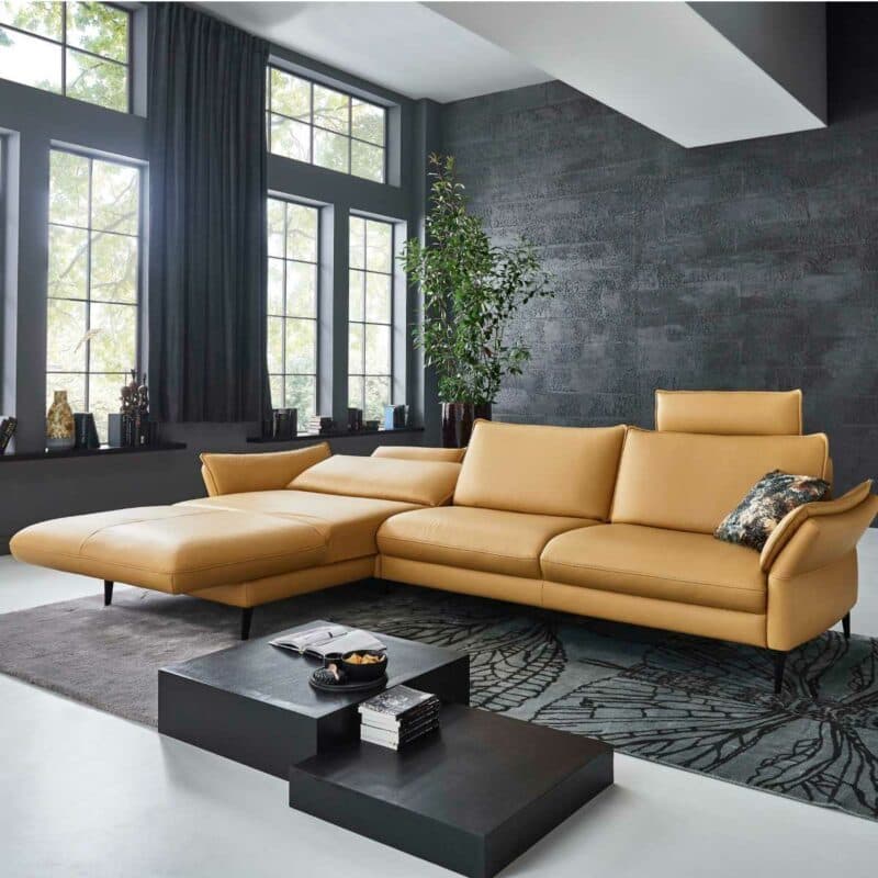 Couchliebe Houston Elementgruppe mit Lederbezug in Curry und Ottomane links als Wohnbeispiel mit Ansicht Liegefunktion.