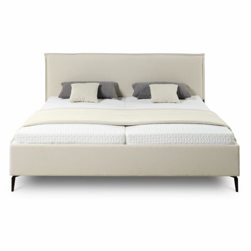 Musterring Elos Polsterbett mit Textilbezug JAB 9895 in Creme, Kopfteil mit Stehsaum und Metallfüßen als Freisteller mit Deko.