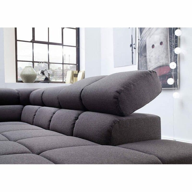 Candy Careno Ecksofa mit Velourbezug in Grau und geneigter Kopfstütze in Detailansicht.