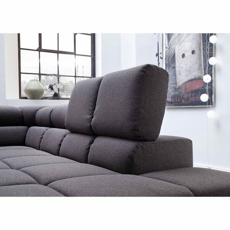 Candy Careno Ecksofa mit Velourbezug in Grau und hochgeklappter Kopfstütze in Detailansicht.