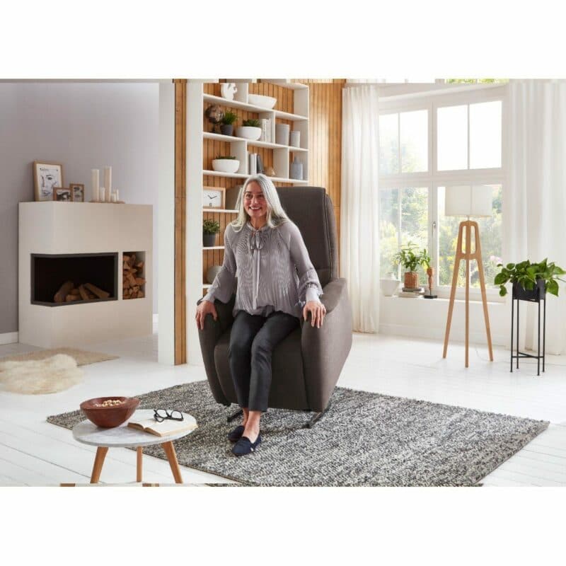 Europa Möbel Collection EM Witten Fernsehsessel in Espresso mit Aufstehhilfe als Wohnbeispiel mit Frau.