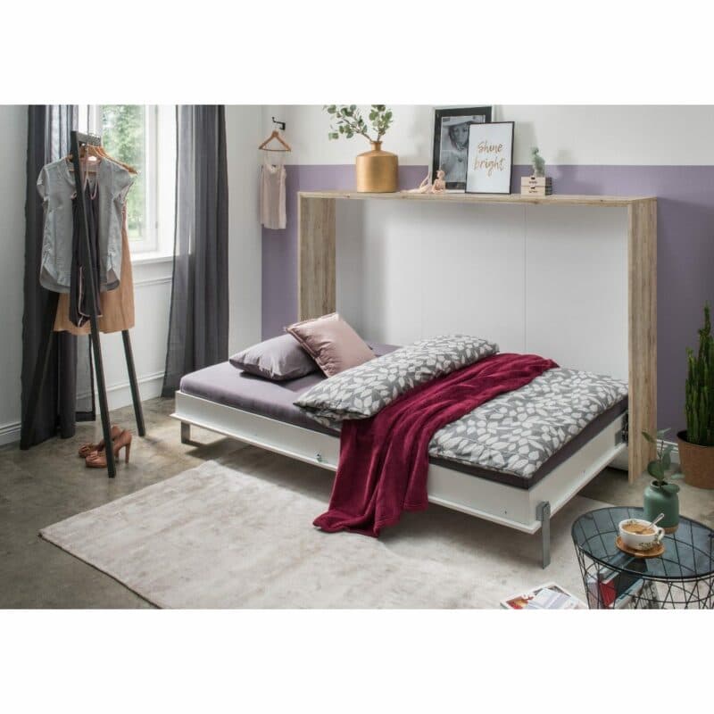 Wimex Juist Schrankbett 120x200 cm mit weißer Front und Korpus in Eiche Dekor als Wohnbeispiel in aufgeklapptem Zustand.