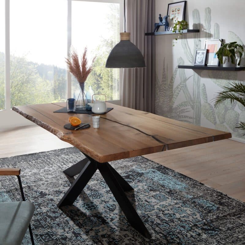 Trendstore Guilio Esstisch in Wildeiche massiv geölt mit Baumkante und Gestell in Metall in schwarz.