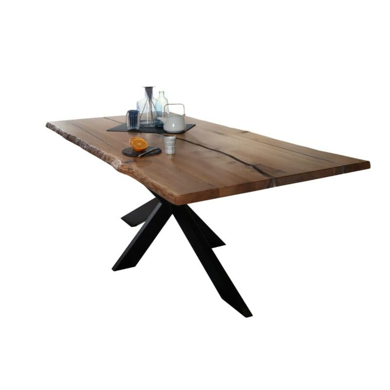 Trendstore Guilio Esstisch in Wildeiche massiv geölt mit Baumkante und Gestell in Metall in schwarz.